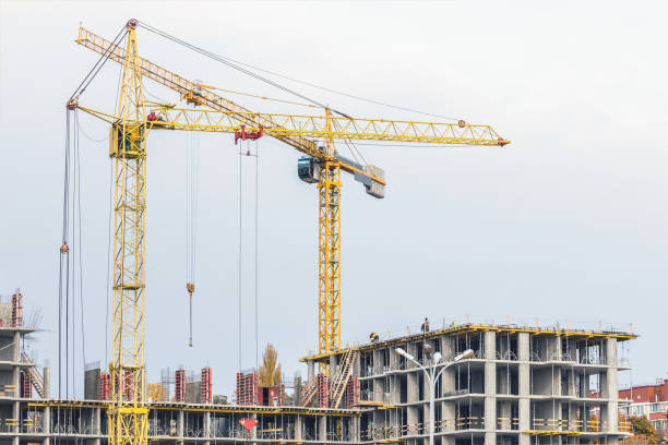 istock Several cranes and buildings against blue sky. Construction site of hightower structure. Abstract construction background 917766382