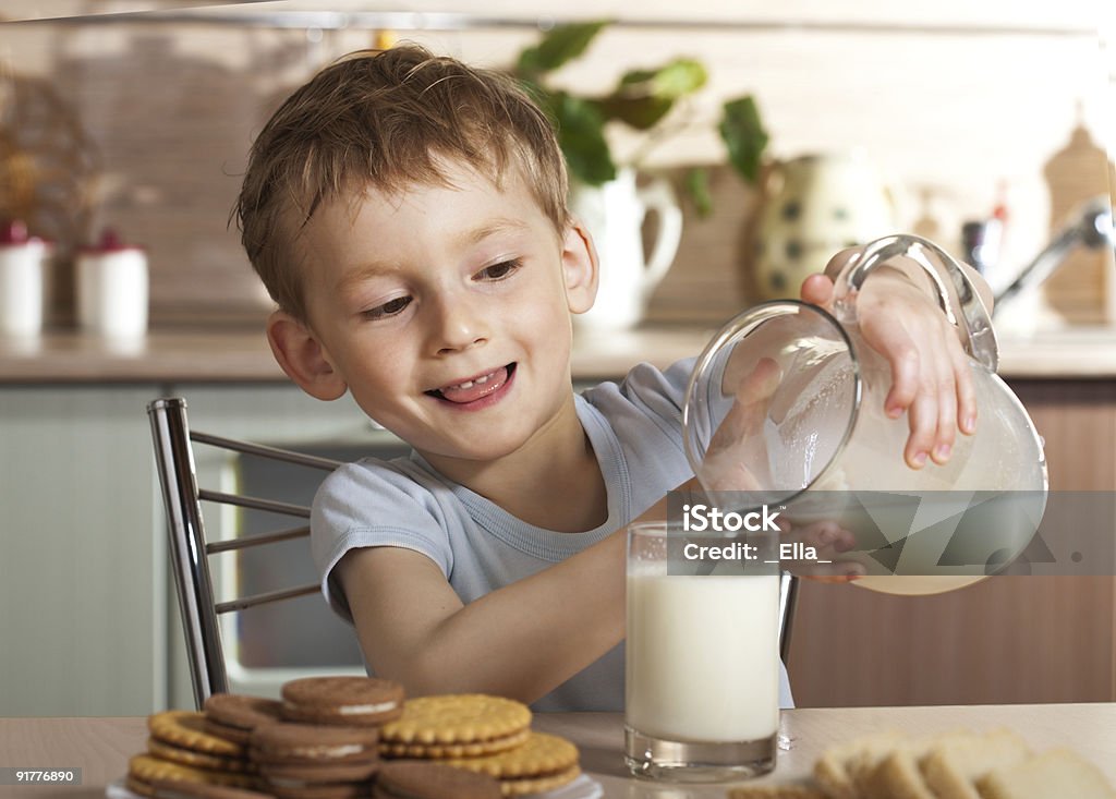 Sain de l'enfant verse du lait de Pichet - Photo de Biscuit libre de droits