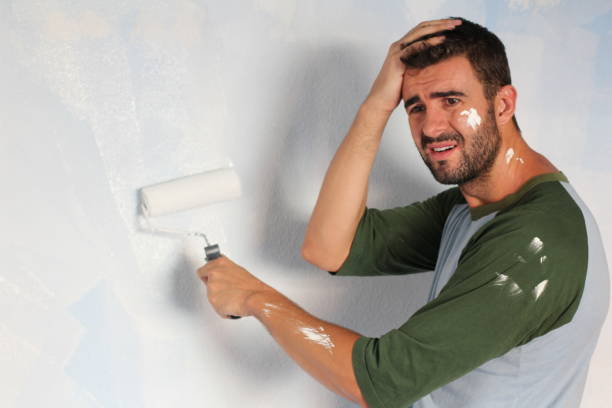 istock Stressed out male painting his home 917777720