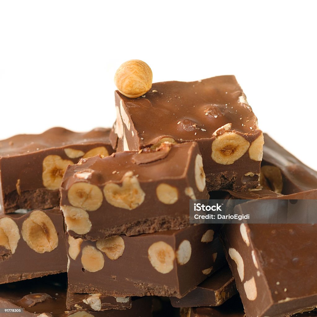 Square trozos de chocolate con la avellana, fondo blanco - Foto de stock de Avellana libre de derechos