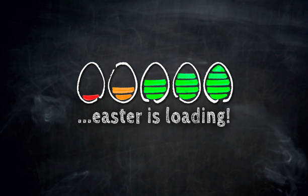 Easter is loading concept with eggs on blackboard stock photo