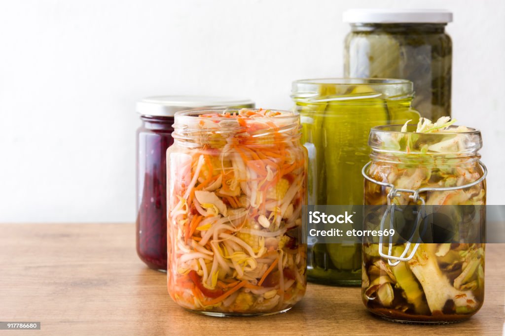 Fermented preserved vegetables in jar Fermented preserved vegetables in jar on wooden table. Fermenting Stock Photo