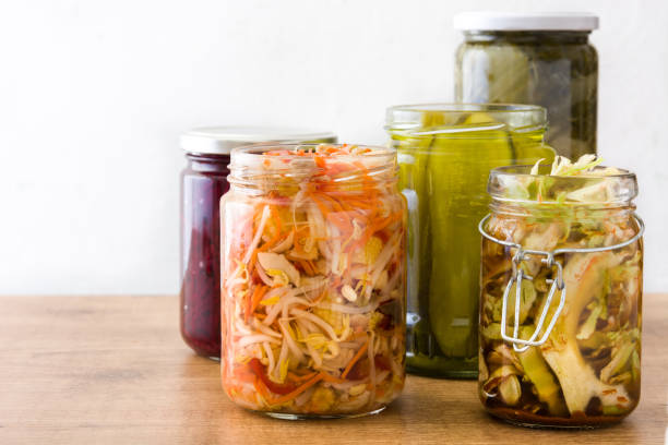 Fermented preserved vegetables in jar Fermented preserved vegetables in jar on wooden table. probiotic stock pictures, royalty-free photos & images