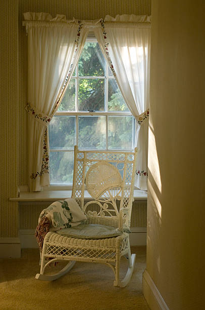 istock White Wicker Rocking Chair in Front of Curtained Window 91778761