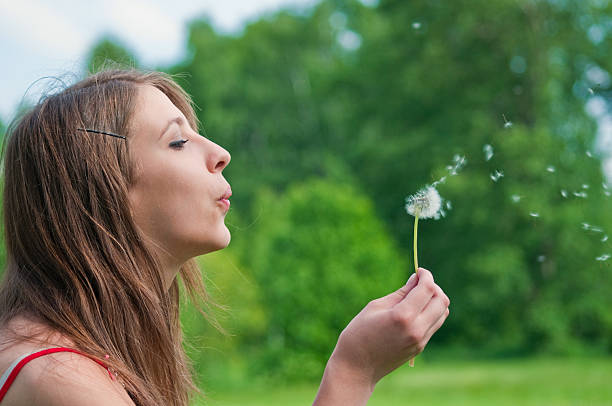istock young woman blowing dandelion 91779132