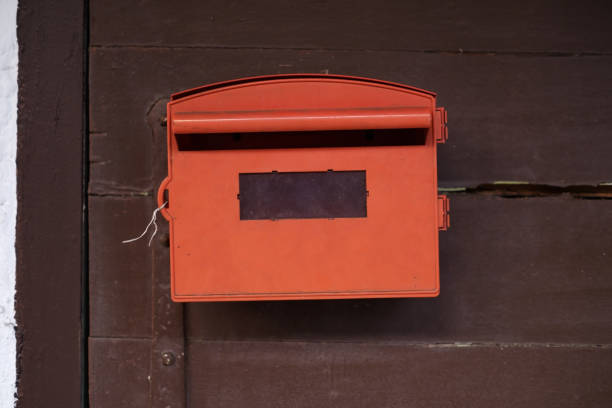 istock Red mailbox with brown wood background. 917793508