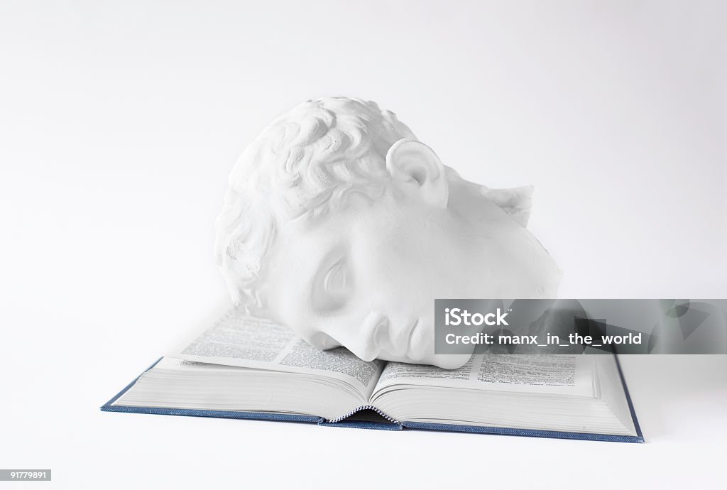 Classical Head on open Book A plaster cast of a classical Roman or Greek statue on an open book. Philosophy Stock Photo