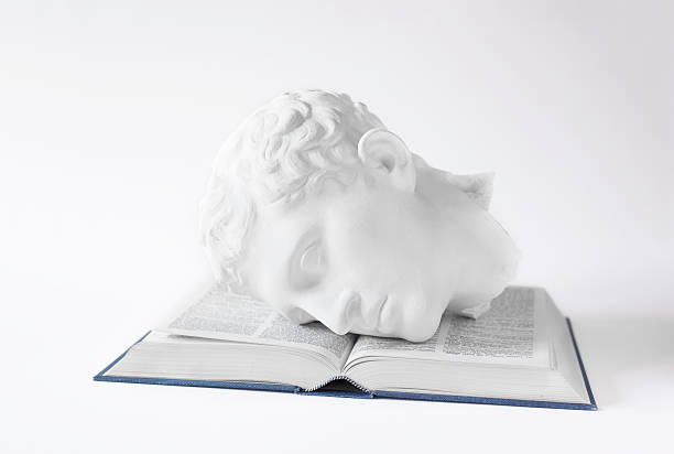 Classical Head on open Book A plaster cast of a classical Roman or Greek statue on an open book. philosophy stock pictures, royalty-free photos & images