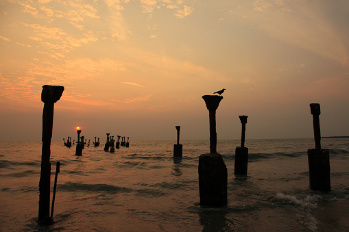 Silhouettes of sea piers during sunset in Calicut beach, Kerala, India