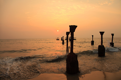 Silhouettes of sea piers during sunset in Calicut beach, Kerala, India