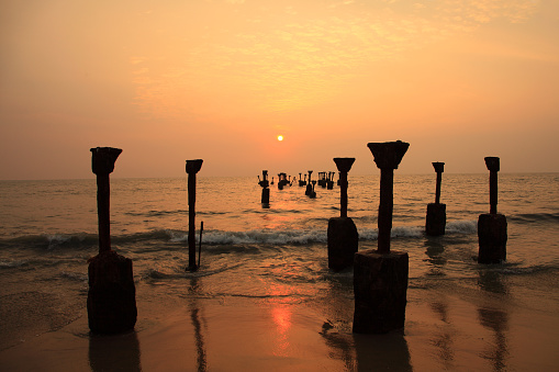 Silhouettes of sea piers during sunset in Calicut beach, Kerala, India