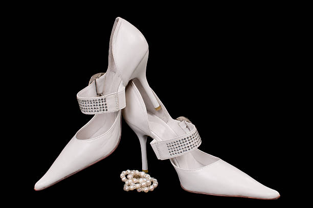 Monochrome closeup image of a wedding shoe with pears.