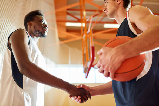 istock Serious basketball players from different team shaking hands 917812678