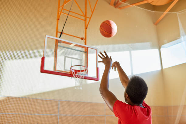 istock Tall African man shooting ball at court 917812692