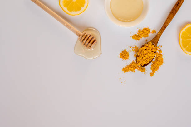 istock Honey stick, spoon with turmeric and lemon slices top view, copy space 917813026