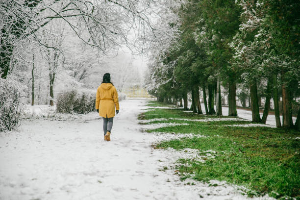 istock woman walk by park where winter meet spring 917814594