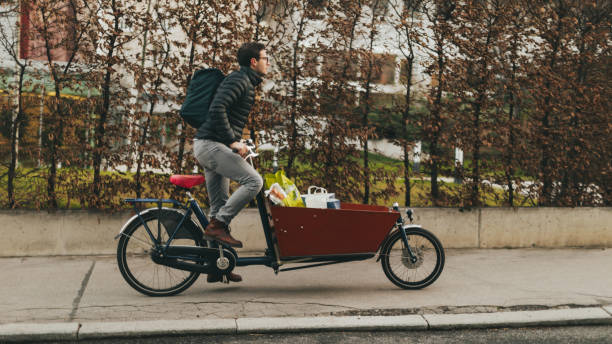 livreur sur un vélo cargo - city bike photos et images de collection