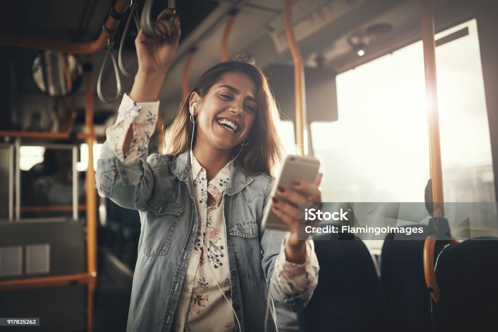 Junge Frau beim Musikhören auf einem Bus lachen - Lizenzfrei Bus Stock-Foto