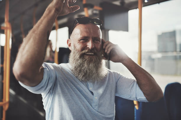 istock Smiling mature man riding a bus talking on his cellphone 917825928