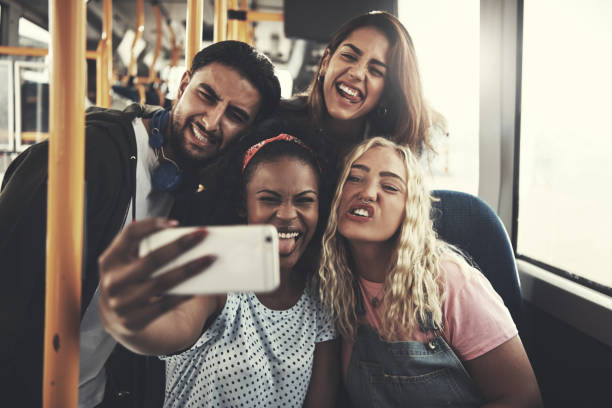istock Smiling diverse friends taking selfies together on a bus 917826172