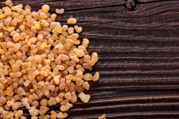 frankincense essential oil on a wooden background.