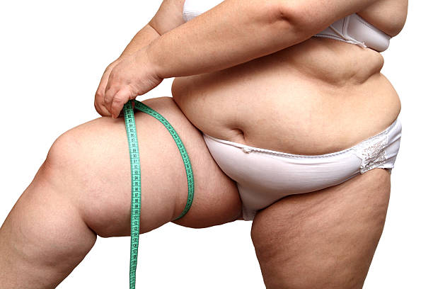 istock overweight woman measure her leg 91783221