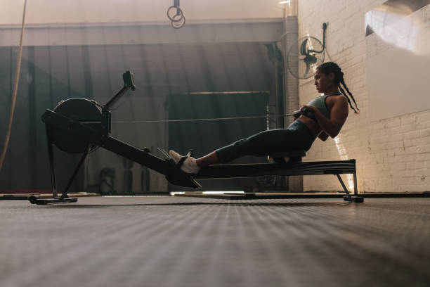 istock Female using rowing machine at health club 917832222