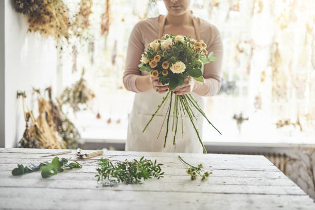 istock Florist making bouquets at a table in her flower shop 917833920