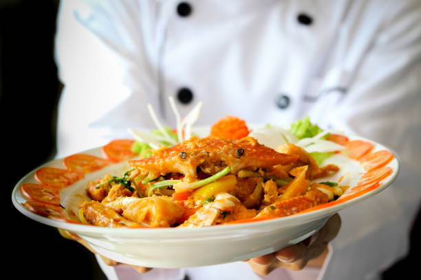 istock Chef proudly presenting Curry Crab with Coconut in dark dramatic background 917837066