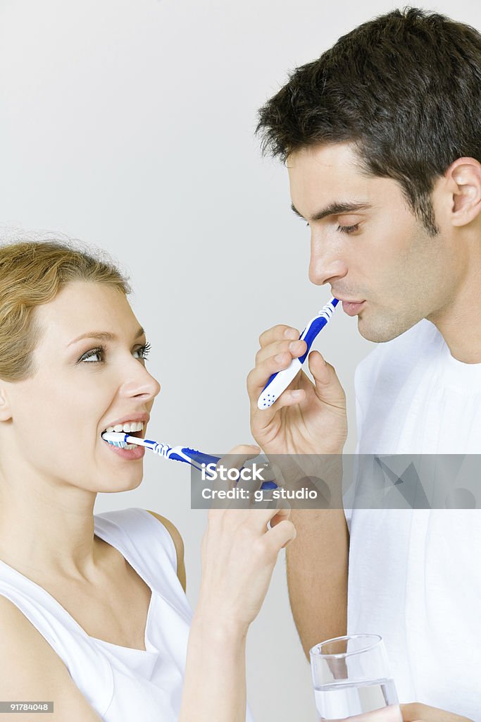 Coppia pulizia denti insieme in bagno - Foto stock royalty-free di 20-24 anni
