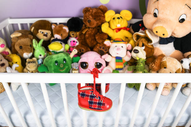 istock Red baby shoes hanging on a white crib fence 917841508
