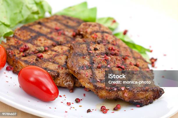 Chuleta De Cerdo Con Lechuga Steak Foto de stock y más banco de imágenes de Asado - Alimento cocinado - Asado - Alimento cocinado, Bistec, Carne