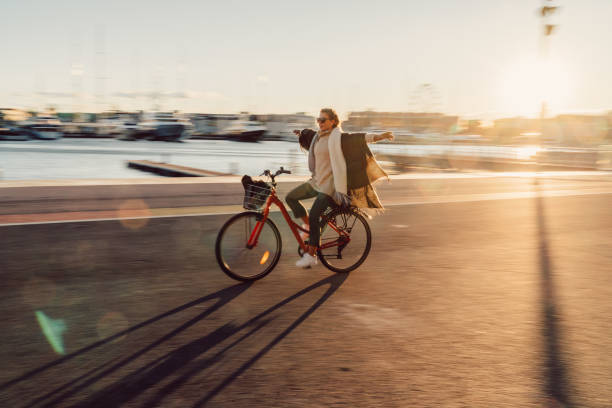 joven, andar en bicicleta con las manos extendidas - travel europe sunset winter fotografías e imágenes de stock