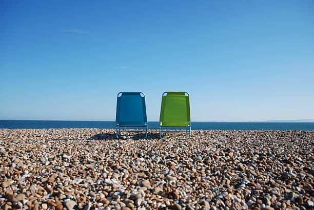 Two deck chairs on beach stock photo