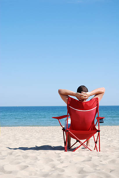 istock Man on deck chair at the beach 91784846