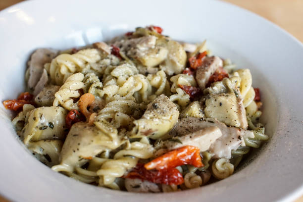 istock fusilli pasta with chicken and red peppers in a white sauce. 917852460