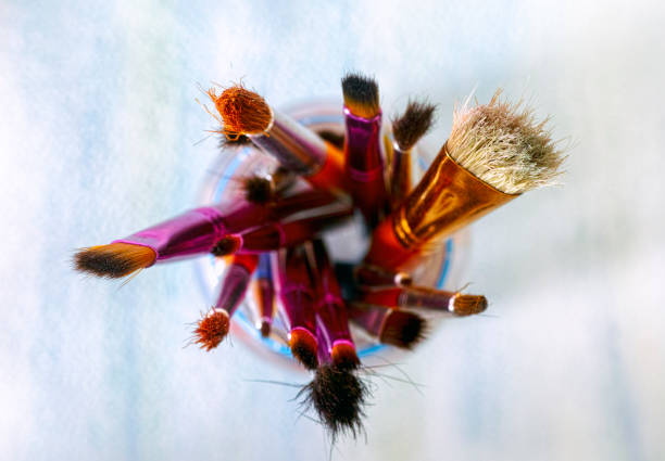 istock Paint brushes in jar on paper background. 917852470