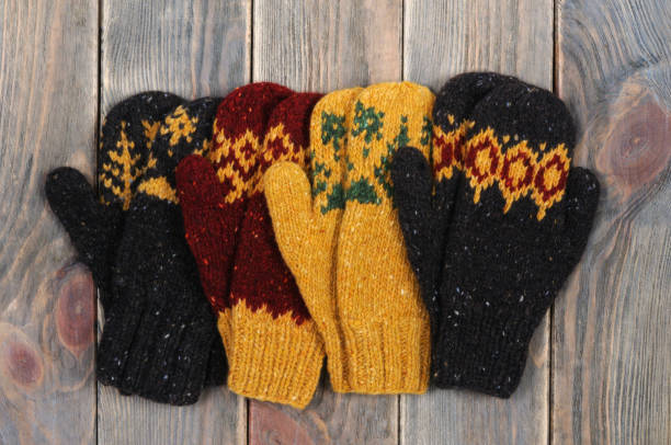 istock Four mittens. Wooden background. View from above. 917853030