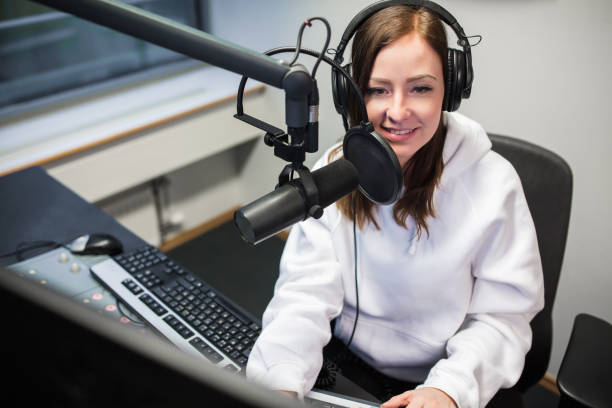 istock Female Jockey Smiling While Communicating On Microphone In Radio 917853728
