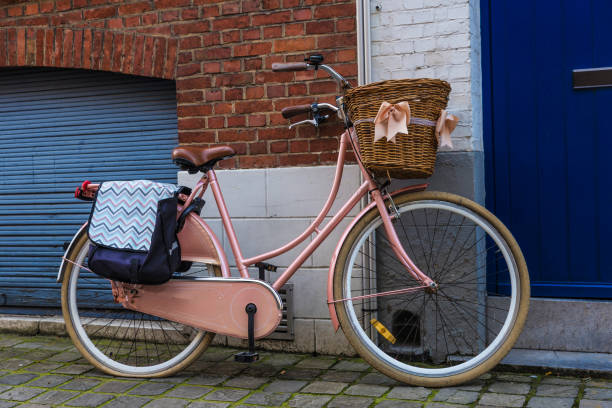 Old vintage bicycle with a wicker basket with ribbons parked on a street in the medieval city of Bruges, Belgium
