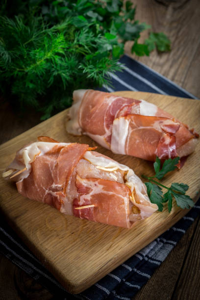 istock Raw chicken breast stuffed with champignon wrapped with bacon. 917858372