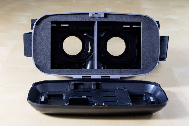 istock Virtual reality goggles on a wooden table. Goggles and computer accessories. Black background 917862654