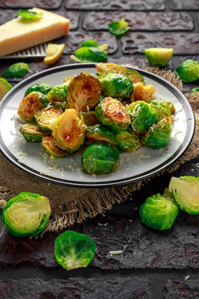 istock Homemade Roasted Brussel Sprouts with Parmesan cheese, lemon, Salt, Pepper on a old stone rustic table 917865416