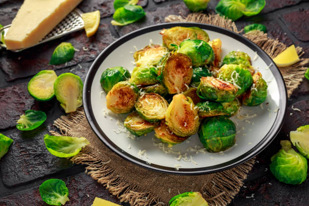 istock Homemade Roasted Brussel Sprouts with Parmesan cheese, lemon, Salt, Pepper on a old stone rustic table 917865476