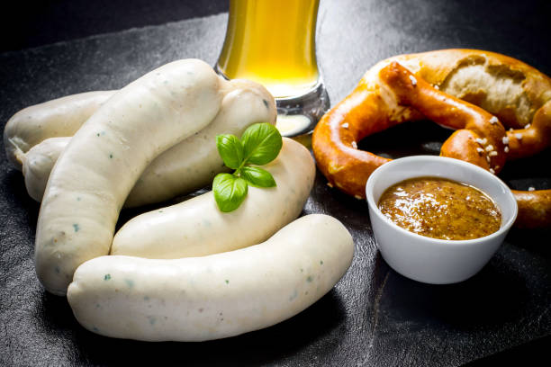 Original Munich sausage with Hefeweizen and pretzel Original Munich sausage with Hefeweizen and pretzel on black slate plate weisswurst photos stock pictures, royalty-free photos & images
