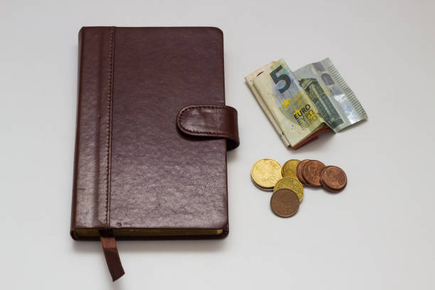 istock Note book and Euro banknotes and coins on a white background 917873752