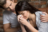 Man comforting crying sad woman, friend consoling girl in tears