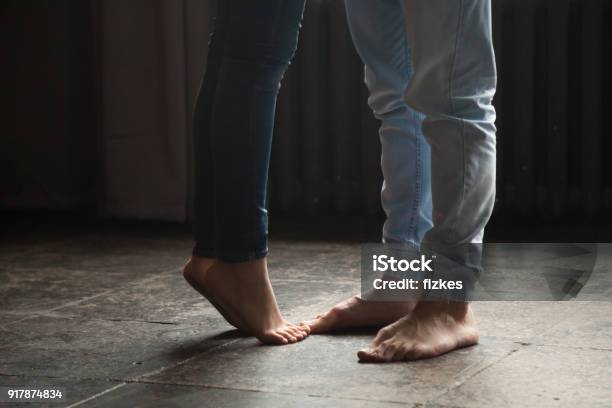 Photo libre de droit de Jeune Fille Debout Sur La Pointe Des Pieds Pour Embrasser Lhomme Couple Pieds Closeup banque d'images et plus d'images libres de droit de Élevé