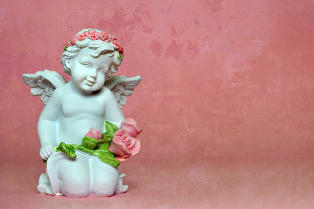 istock Angel kneeling and holding flowers 917874968