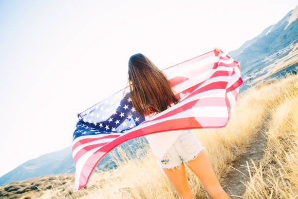 istock Young Woman with American Flag 917877592
